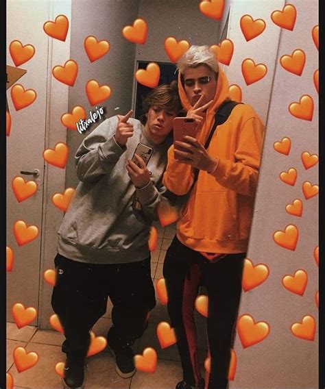 Two People Taking A Selfie In Front Of A Mirror With Hearts All Over It