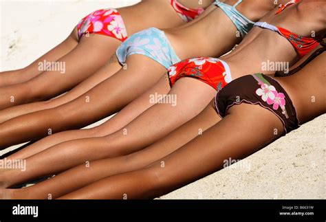 Quatre filles en bikini allongée sur le sable Photo Stock Alamy