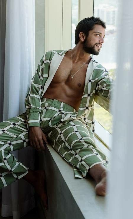 A Man In Green And White Pajamas Sitting On A Window Sill