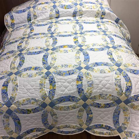 A Blue And White Quilted Bedspread On A Bed