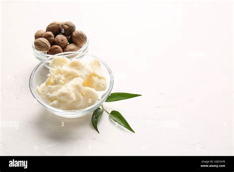 Bowls With Shea Butter And Nuts On Light Background Stock Photo Alamy