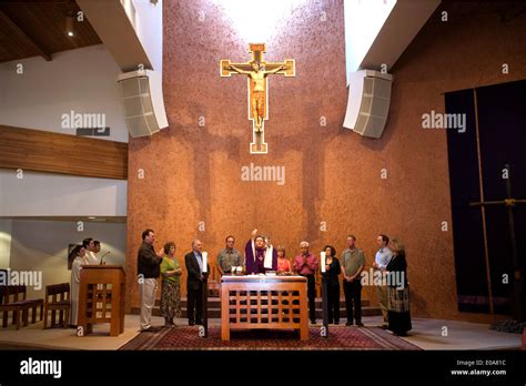 Holding the host and chalice, a Catholic priest celebrates mass in Laguna Niguel, CA. Note altar ...