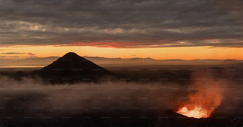 A Volcano Spewing Out Lava At Sunset Photo Iceland Image On Unsplash