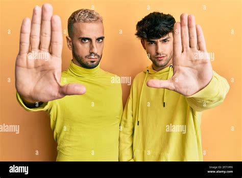 Homosexuel gay couple debout ensemble portant des vêtements jaunes faisant cesser de chanter