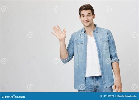 Portrait Of Athletic Handsome Man Waving And Looking Friendly At Camera