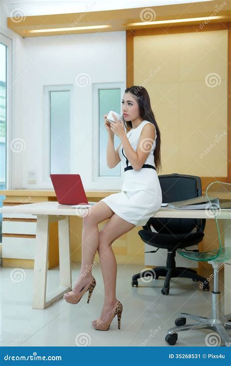 Beautiful Asian Business Woman Standing At Her Desk In Office Stock