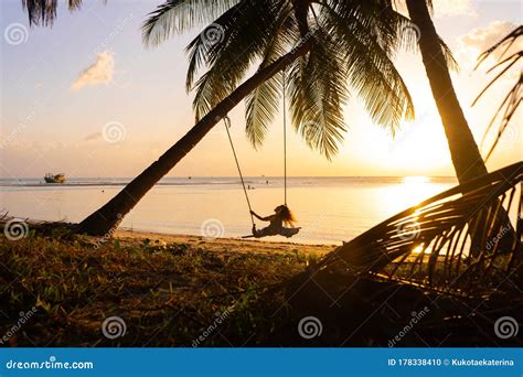 The Girl On The Beach Rides On A Swing During Sunset Sunset In The