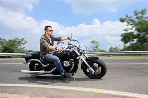 Download Young Man Riding A Motorcycle On An Open Road Stock Image