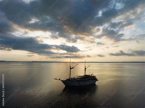 A Tranquil Sunrise Illuminates A Phinisi Schooner On The Pacific Ocean