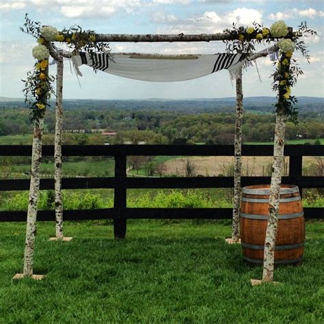 Birch Chuppah Adorned With White Yellow Flowers And Greenery