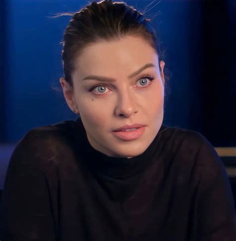 a close up of a person wearing a black shirt and looking at the camera ...