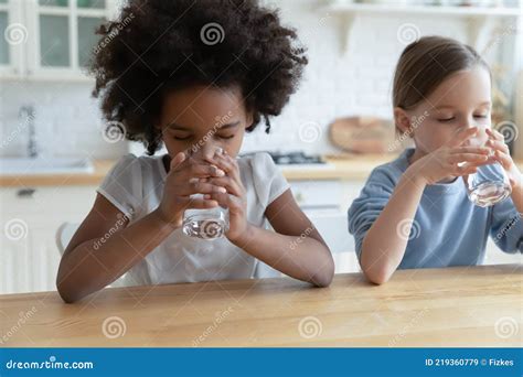 Thirsty Multiethnic Girls Children Drink Water At Home Stock Image