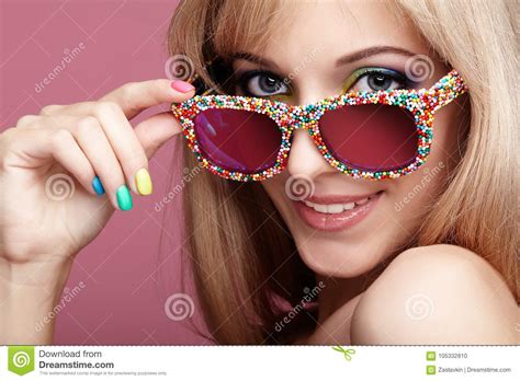 Jonge Blonde Glimlachende Vrouw Met De Glazen Van Het Pretsuikergoed Op Roze Backg Stock Foto