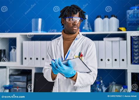 African American Man Scientist Writing On Clipboard At Laboratory Stock