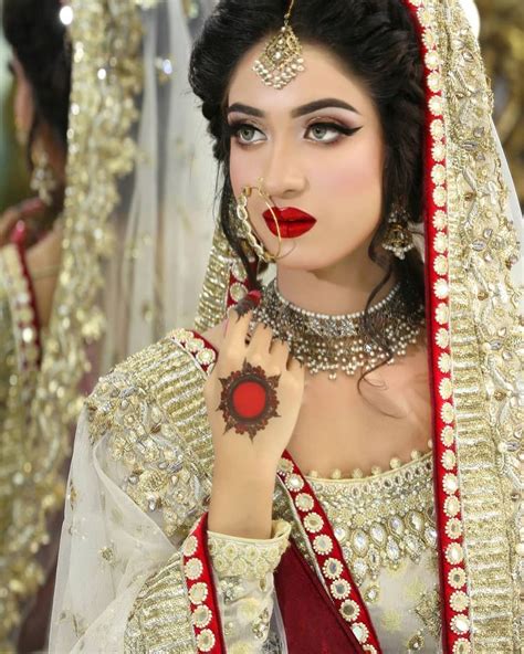 A Woman Wearing A Bridal Outfit And Holding Her Hands To Her Face While