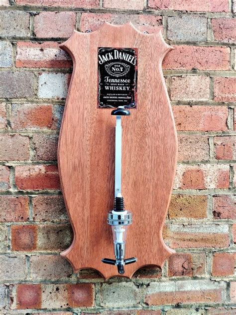 A Wooden Plaque Mounted To The Side Of A Brick Wall With A Water Faucet