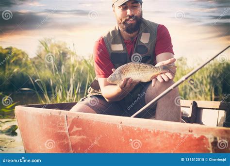 Pescador Que Mostra Os Peixes Pesca De Sorriso Do Homem Como O