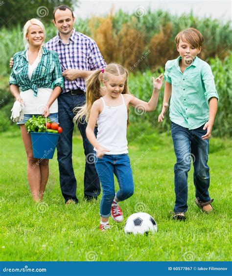 Familia De Cuatro Miembros Feliz Que Juega A F Tbol Imagen De Archivo