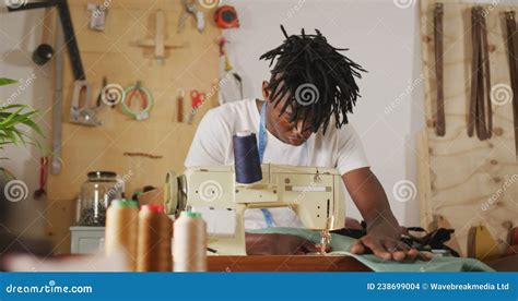 Focused African American Craftsman With Dreadlocks Using Sewing Machine