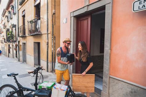 Premium Photo Smiling Young Couple Holding Speaker Outside Building