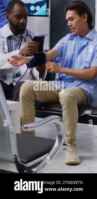 Vertical Video Cardiologist Using Medical Tonometer To Measure Patient