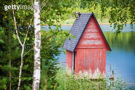 A Small Red Wooden House Near The Lake And The Forest Close Up Latvia