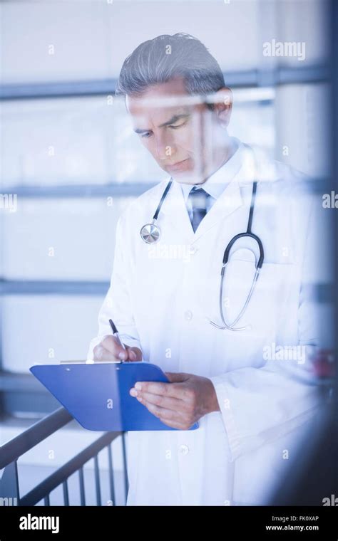 Male Doctor Writing On Clipboard Stock Photo Alamy