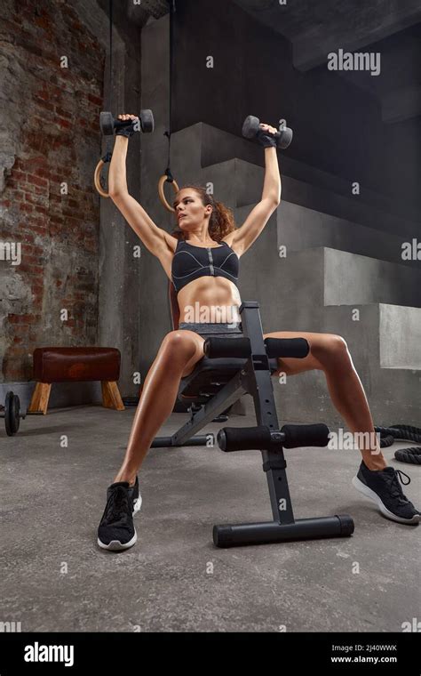 Gorgeous Brunette Lifting Some Weights And Training Her Biceps In A Gym