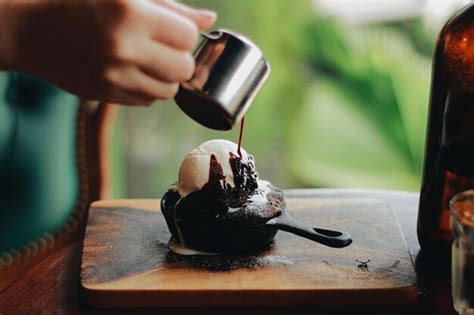 Premium Photo Cropped Hand Pouring Chocolate On Ice Cream