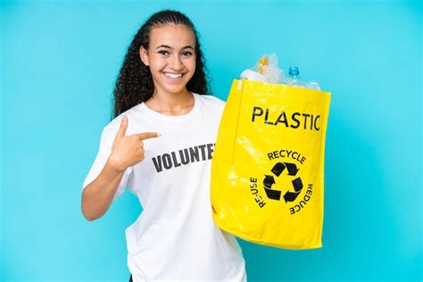 Mujer joven sosteniendo una bolsa llena de botellas de plástico para