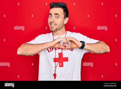 Handsome Lifeguard Man Wearing T Shirt With Red Cross And Whistle Over