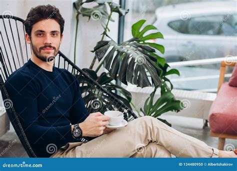 Attractive Bearded Man With A Cup Of Tea Is Posing To The Camera Stock