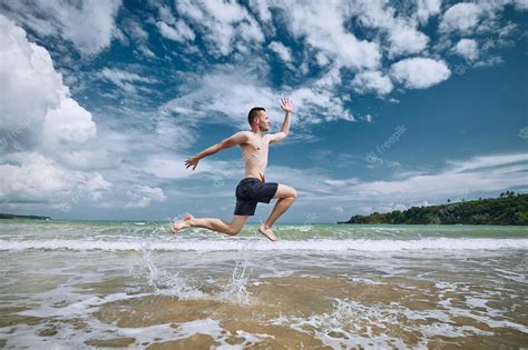 Premium Photo | Joyful man jumping on beach