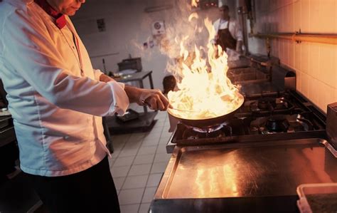 Premium Photo Chef Cooking And Doing Flambe On Food In Restaurant Kitchen