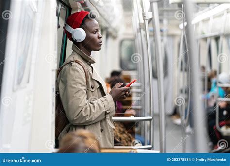 Afro American Passenger Man In Red Hat Trench Coat Stand In Subway