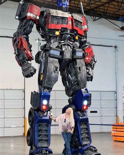 a woman standing next to a giant robot