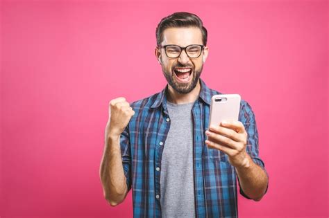 Homem Feliz Segurando O Smartphone E Comemorando Seu Sucesso Foto