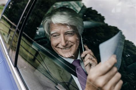 Premium Photo Smiling Senior Businessman With Documents On The Phone