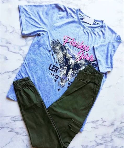 A Blue Shirt With An Eagle On It Next To Green Pants And A Pair Of Sneakers