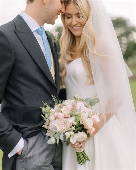 A Bride And Groom Standing Together In Front Of The Camera With Their