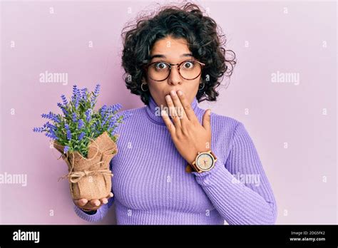 Young Hispanic Woman With Curly Hair Holding Lavender Plant Covering