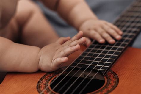 A Child Playing Brown Acoustic Guitar · Free Stock Photo