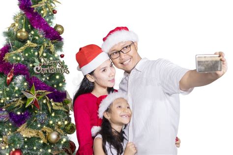 Familia Que Toma La Imagen Del Selfie Cerca Del árbol De Navidad Foto