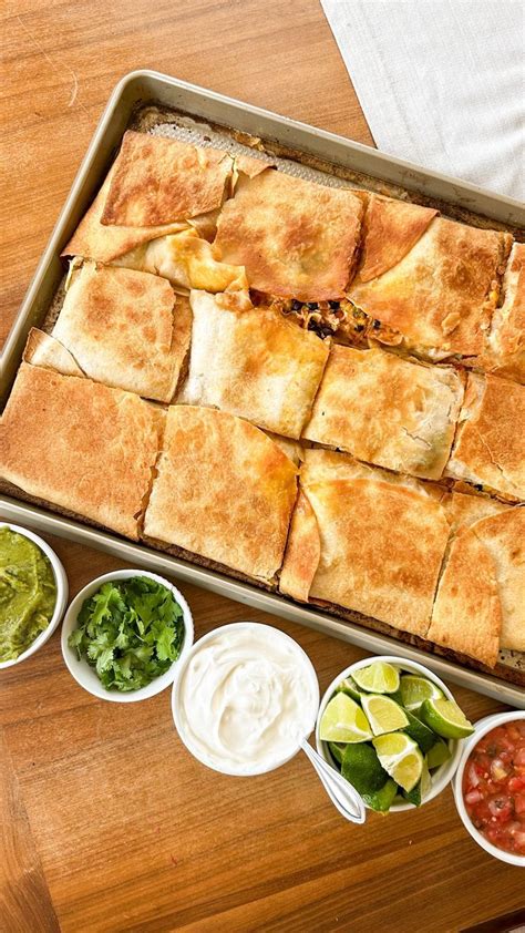 A Pan Filled With Food On Top Of A Wooden Table Next To Bowls Of