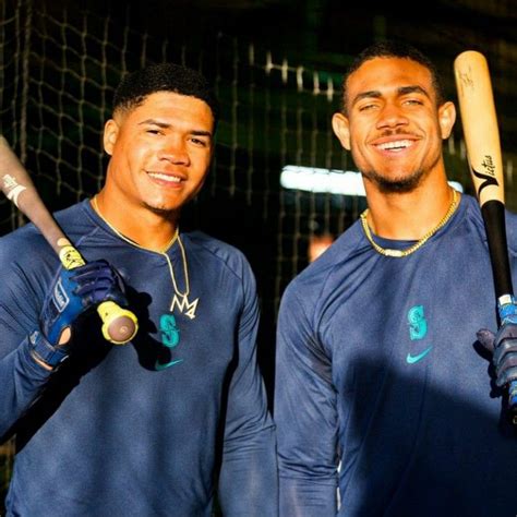 Two Men Holding Baseball Bats In Their Hands