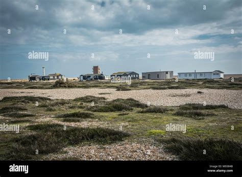 Buildings On A Windswept Dungeness Beach Kent England UK Stock Photo