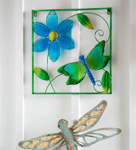 A Metal Dragon Figurine Sitting On Top Of A Table Next To A Blue Flower