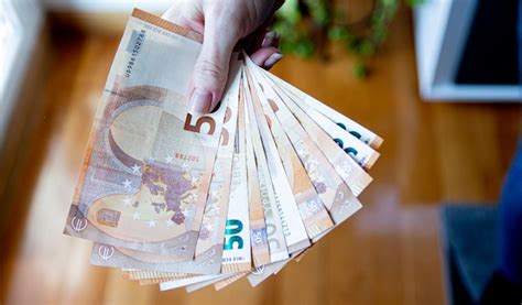 Premium Photo A Person Holding A Stack Of Euro Banknotes