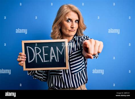 Middle Age Beautiful Blonde Dreamer Woman Holding Blackboard With Dream