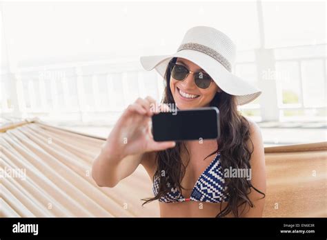 Pretty Brunette Relaxing On A Hammock And Taking Selfie Stock Photo Alamy